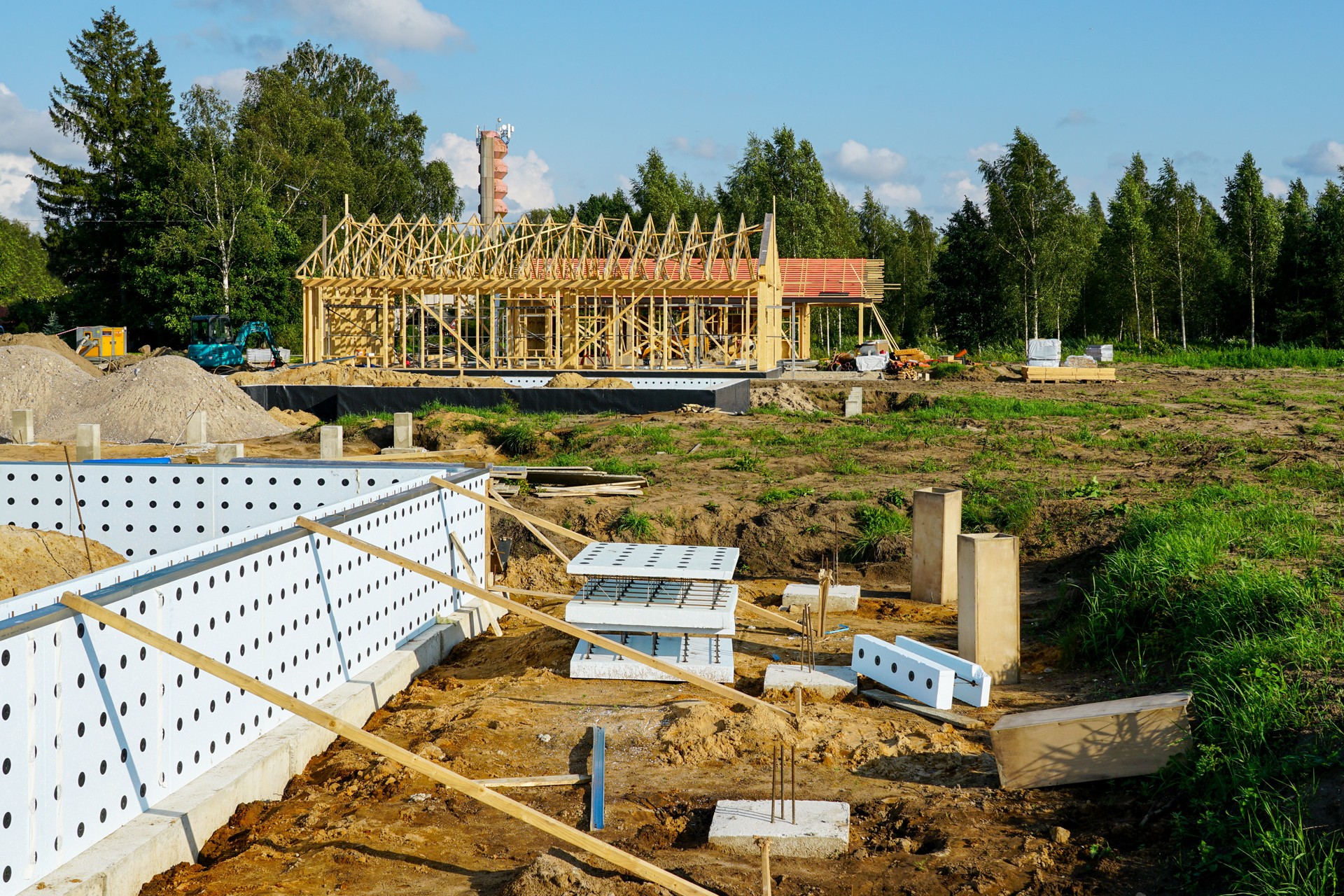 ICF foundation system with timber framing construction in background at residential building site
